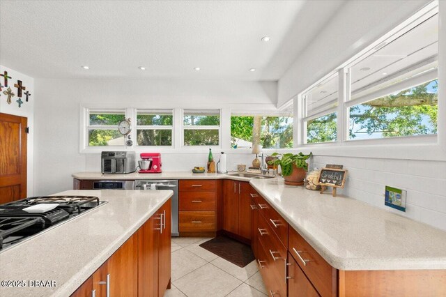 101 Azalea Cir, New Smyrna Beach, FL 32168 - kitchen featuring backsplash, appliances with stainless steel finishes, brown cabinetry, healthy amount of natural light, and recessed lighting