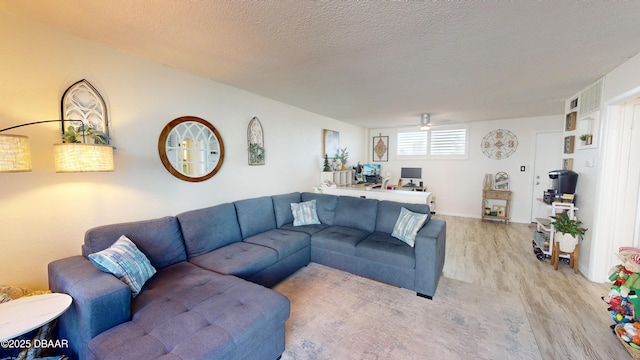 living room featuring a textured ceiling and light wood-style floors