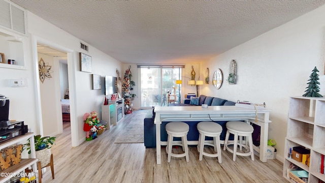 interior space with a textured ceiling, wood finished floors, and visible vents