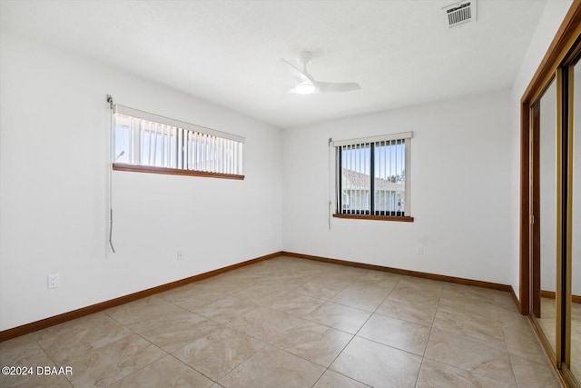 22 Upper Cay Dr, Ormond Beach, FL 32176 - unfurnished bedroom with ceiling fan, visible vents, light tile patterned floors, baseboards, and a closet