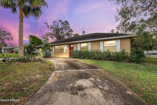 ranch-style home with a yard