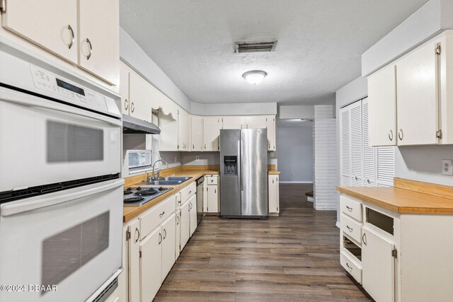 kitchen featuring white cabinets, dark hardwood / wood-style flooring, sink, and appliances with stainless steel finishes