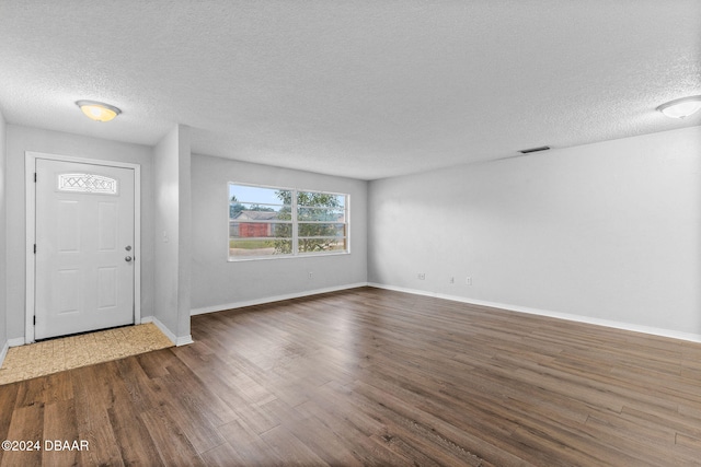 foyer with a textured ceiling and dark hardwood / wood-style floors