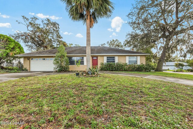 ranch-style house with a garage and a front lawn