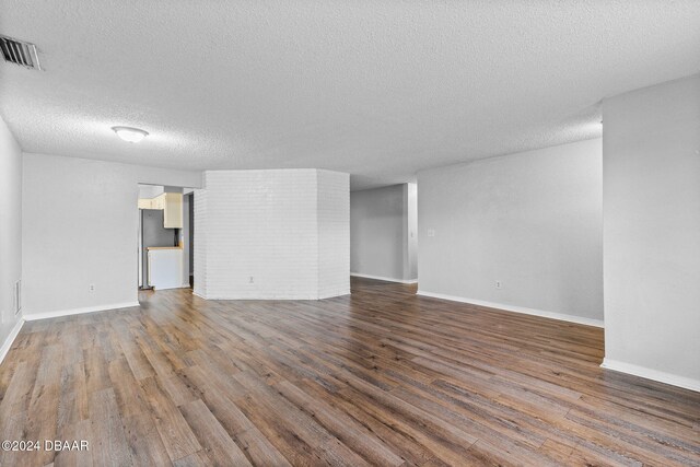 empty room featuring a textured ceiling and dark hardwood / wood-style flooring