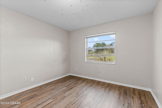 unfurnished room with hardwood / wood-style floors