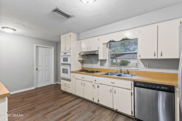 kitchen with sink, dark hardwood / wood-style flooring, a textured ceiling, white cabinets, and appliances with stainless steel finishes