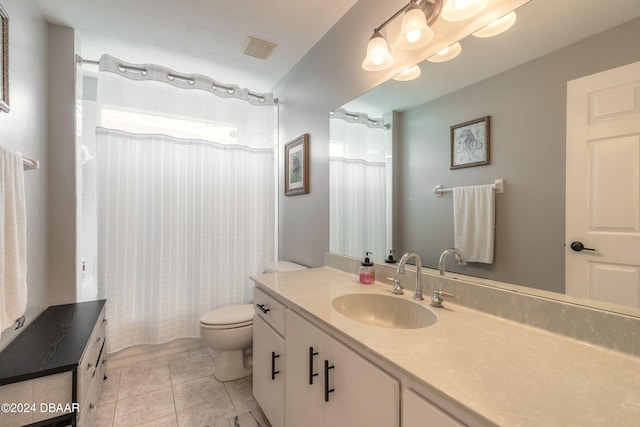 bathroom with tile patterned flooring, vanity, and toilet