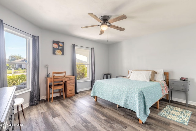 bedroom with dark hardwood / wood-style flooring, multiple windows, and ceiling fan