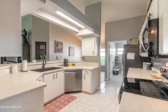 kitchen featuring white cabinets, sink, vaulted ceiling, kitchen peninsula, and stainless steel appliances