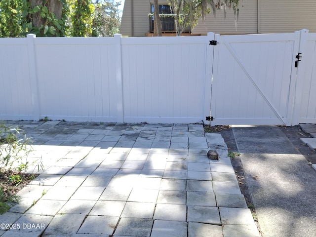 view of gate featuring a patio area and fence