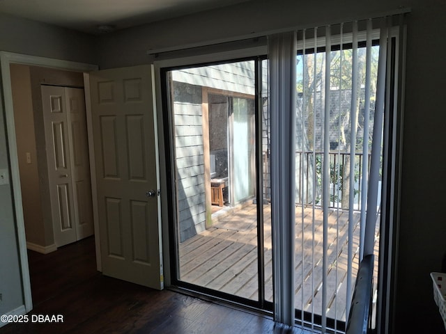 doorway featuring baseboards and dark wood-style flooring