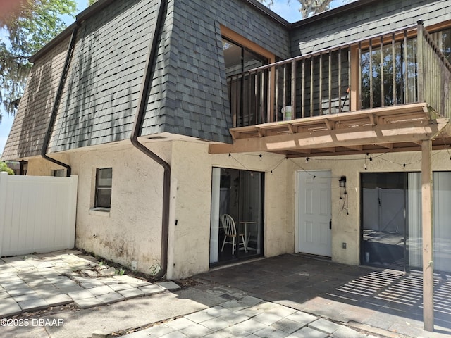 81 Springwood Sq, Port Orange, FL 32129 - back of house with mansard roof, a patio area, and stucco siding