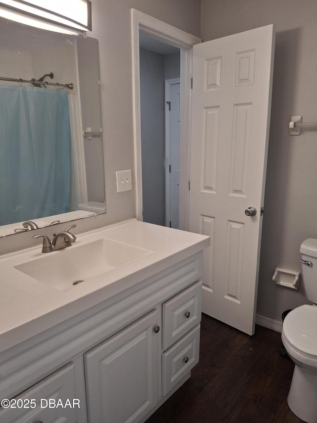 full bath with wood finished floors, vanity, baseboards, toilet, and a shower with shower curtain