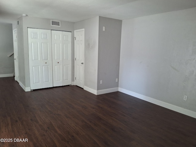 81 Springwood Sq, Port Orange, FL 32129 - unfurnished bedroom with dark wood-style floors, baseboards, and a closet