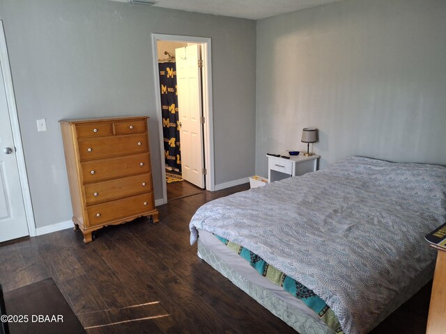 bedroom featuring baseboards and dark wood-style flooring