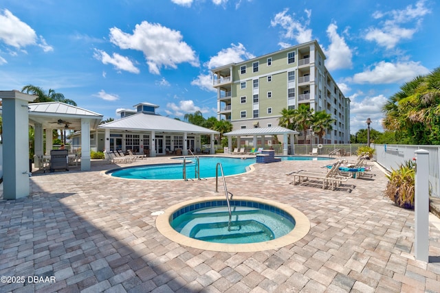 pool with a community hot tub, fence, a ceiling fan, a gazebo, and a patio area