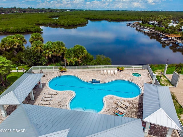 community pool featuring a water view, fence, and a patio