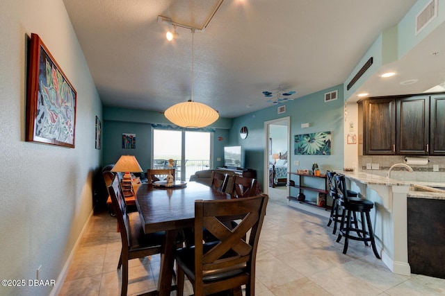 dining area featuring light tile patterned floors, visible vents, and baseboards