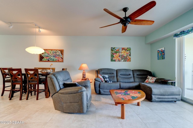 living area featuring rail lighting, a healthy amount of sunlight, and ceiling fan