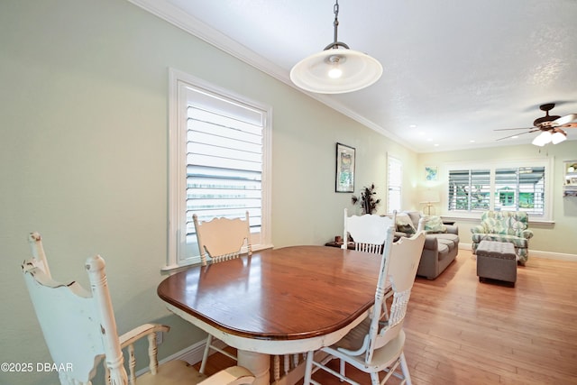 dining space with crown molding, ceiling fan, and light hardwood / wood-style flooring