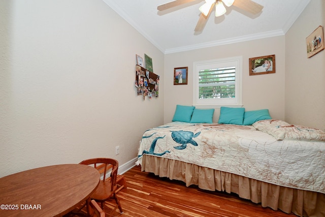 bedroom with hardwood / wood-style flooring, ornamental molding, and ceiling fan