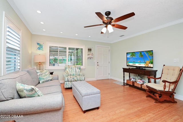 living room featuring crown molding, light hardwood / wood-style flooring, and ceiling fan