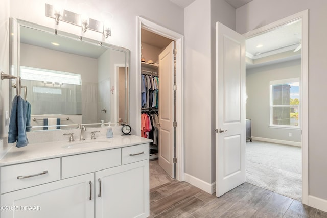 557 Mosaic Blvd, Daytona Beach, FL 32124 - bathroom with vanity, wood finished floors, baseboards, and a spacious closet