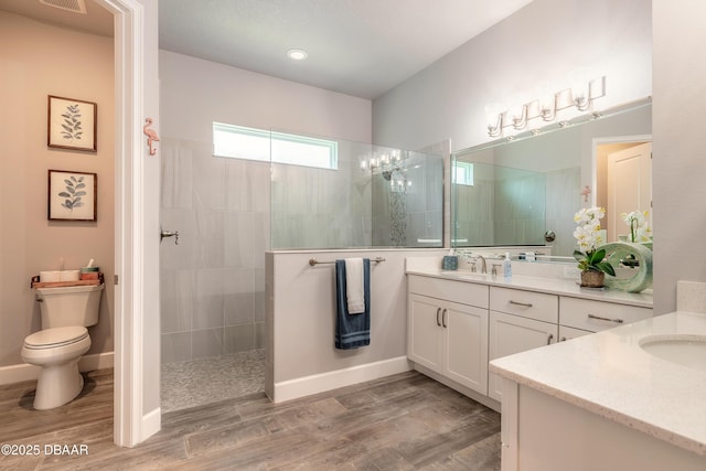 557 Mosaic Blvd, Daytona Beach, FL 32124 - full bath with vanity, a walk in shower, toilet, wood finished floors, and baseboards