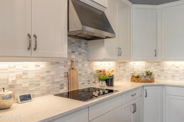 557 Mosaic Blvd, Daytona Beach, FL 32124 - kitchen with exhaust hood, black electric cooktop, white cabinets, and backsplash