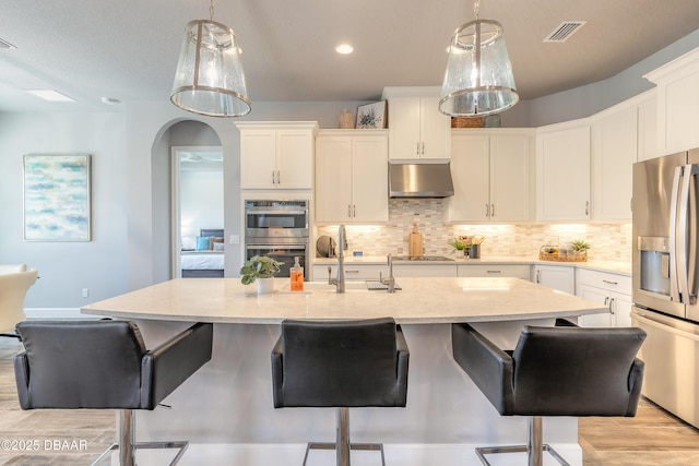 557 Mosaic Blvd, Daytona Beach, FL 32124 - kitchen with stainless steel appliances, under cabinet range hood, tasteful backsplash, decorative light fixtures, and recessed lighting