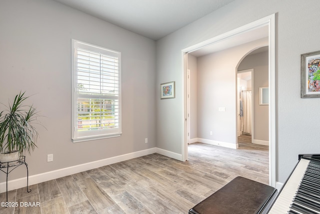 557 Mosaic Blvd, Daytona Beach, FL 32124 - empty room featuring arched walkways, light wood-type flooring, and baseboards