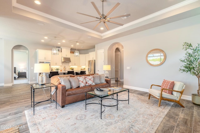 557 Mosaic Blvd, Daytona Beach, FL 32124 - living room with arched walkways, a raised ceiling, recessed lighting, light wood-style floors, and a ceiling fan