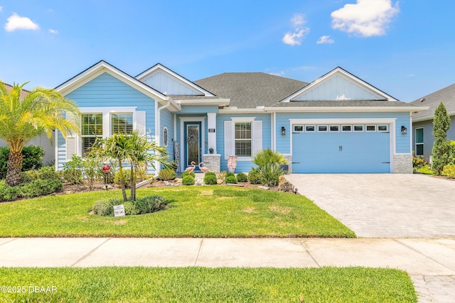 557 Mosaic Blvd, Daytona Beach, FL 32124 - view of front of house featuring a front yard, an attached garage, driveway, board and batten siding, and a shingled roof