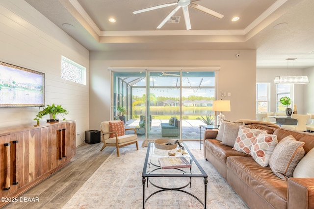 557 Mosaic Blvd, Daytona Beach, FL 32124 - living room featuring a raised ceiling, light wood-style floors, ceiling fan, and a water view