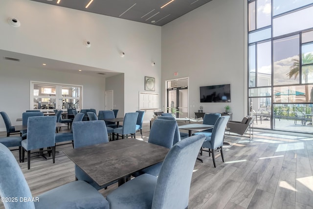 557 Mosaic Blvd, Daytona Beach, FL 32124 - dining space with a high ceiling, light wood finished floors, and a wall of windows