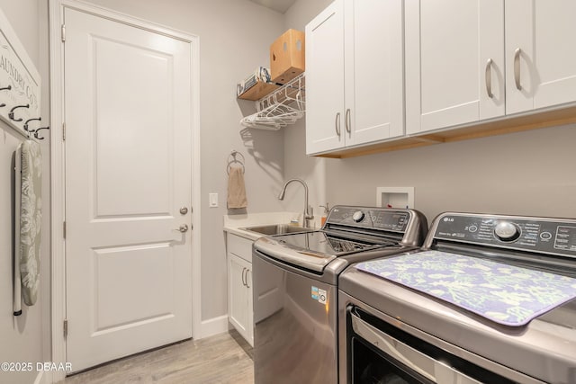 557 Mosaic Blvd, Daytona Beach, FL 32124 - laundry room with washer and clothes dryer, light wood finished floors, cabinet space, and baseboards