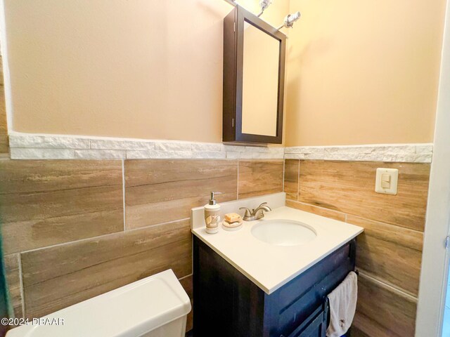 2801 N Halifax Ave Unit 250, Daytona Beach, FL 32118 - half bathroom with vanity, a wainscoted wall, and tile walls