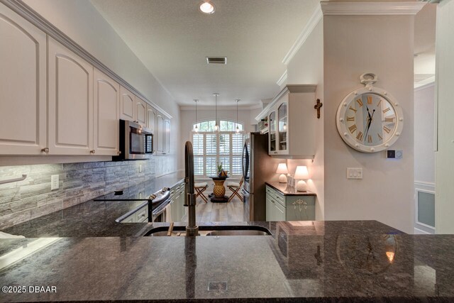 1455 Carlow Cir, Ormond Beach, FL 32174 - kitchen with appliances with stainless steel finishes, a sink, decorative backsplash, glass insert cabinets, and dark stone counters