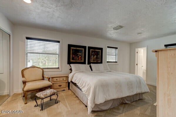 carpeted bedroom featuring a textured ceiling