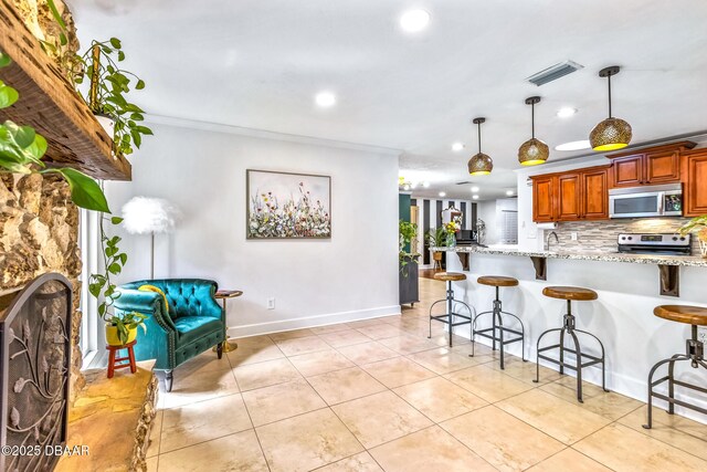 887 Sugar House Ct, Port Orange, FL 32129 - kitchen with stainless steel appliances, a breakfast bar area, recessed lighting, light stone countertops, and backsplash