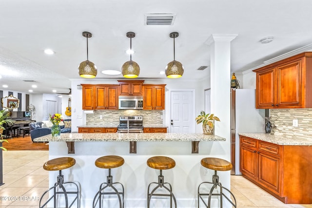 887 Sugar House Ct, Port Orange, FL 32129 - kitchen featuring stainless steel appliances, light tile patterned floors, decorative backsplash, a kitchen breakfast bar, and recessed lighting