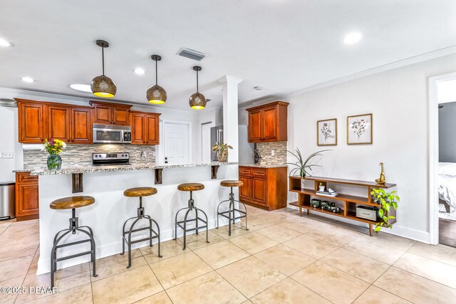 887 Sugar House Ct, Port Orange, FL 32129 - kitchen with appliances with stainless steel finishes, tasteful backsplash, ornamental molding, a kitchen bar, and light stone counters
