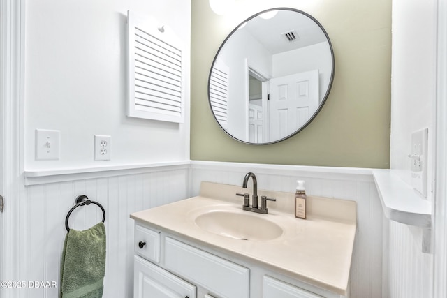 887 Sugar House Ct, Port Orange, FL 32129 - bathroom with wainscoting, vanity, and a decorative wall