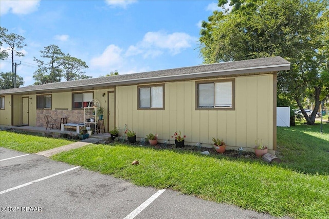 ranch-style house with uncovered parking and a front lawn