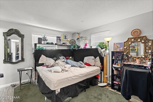 bedroom featuring baseboards, a textured ceiling, and wood finished floors