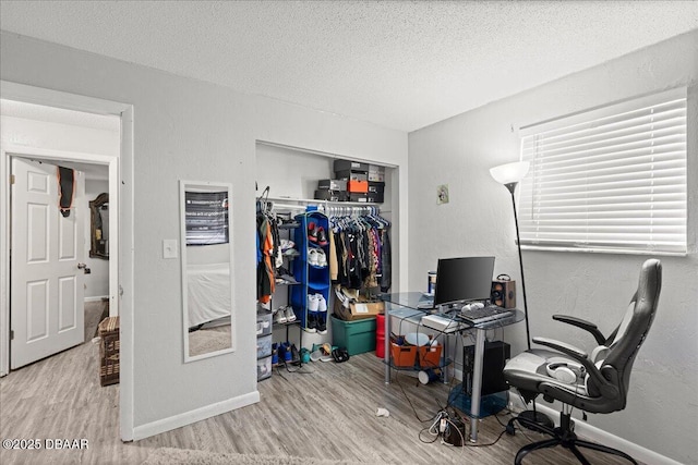 office featuring a textured ceiling, baseboards, and wood finished floors