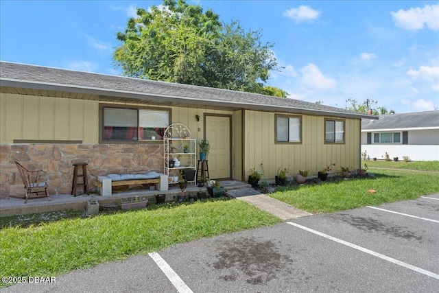 view of front of home featuring uncovered parking and a front lawn