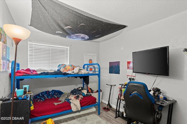 bedroom featuring a textured ceiling and wood finished floors