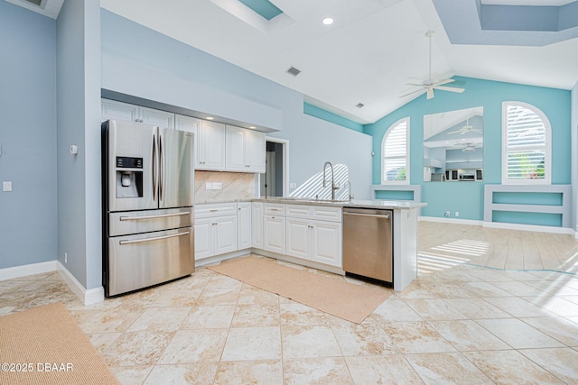 kitchen with stainless steel appliances, light countertops, white cabinetry, a ceiling fan, and a peninsula